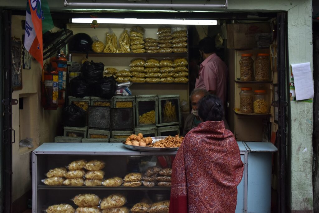a woman standing in front of a store filled with food