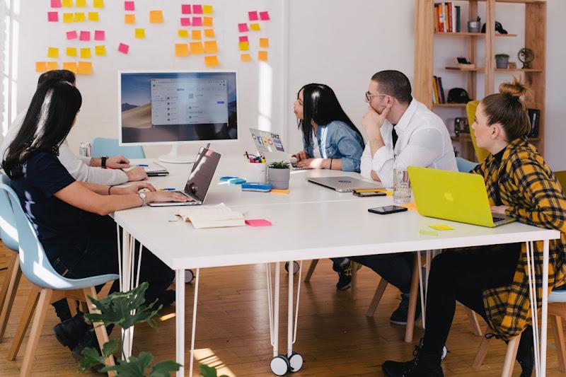 A team in an office discussing organizational knowledge management during a meeting