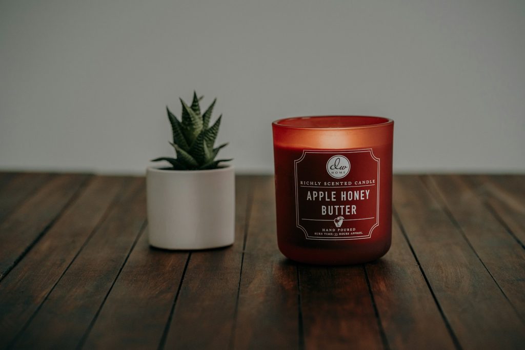 a candle sitting on a table next to a potted plant