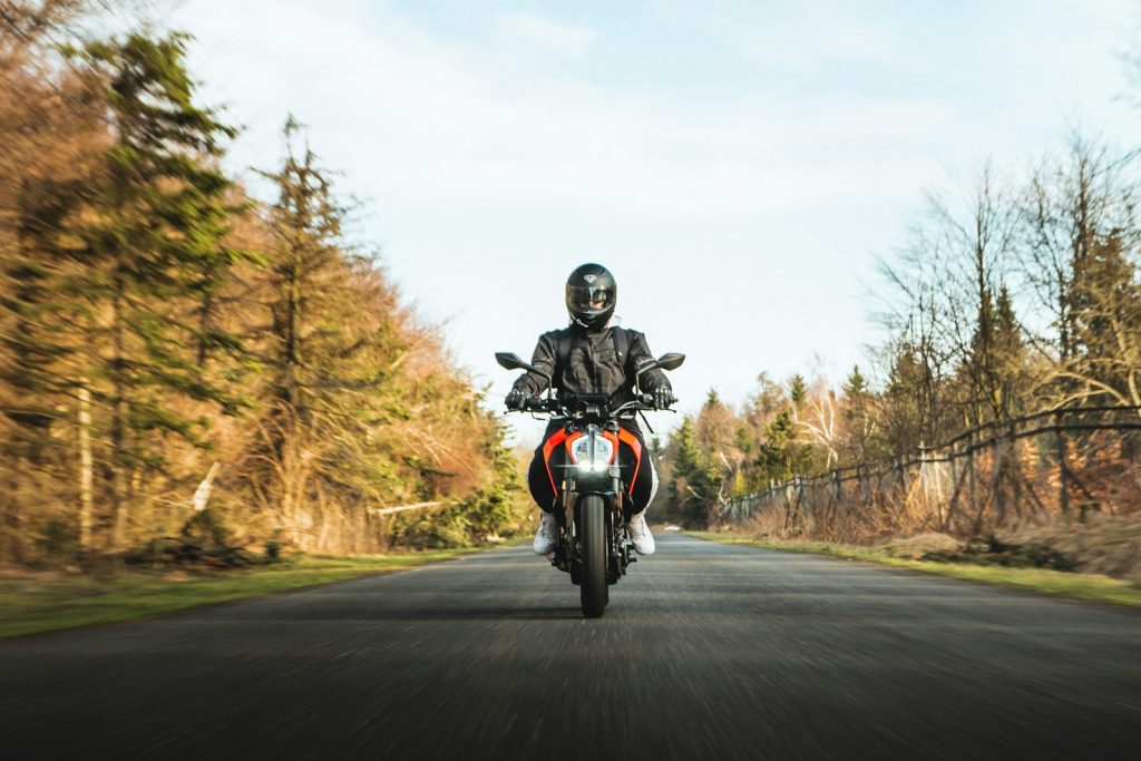 man in black helmet riding motorcycle on road during daytime