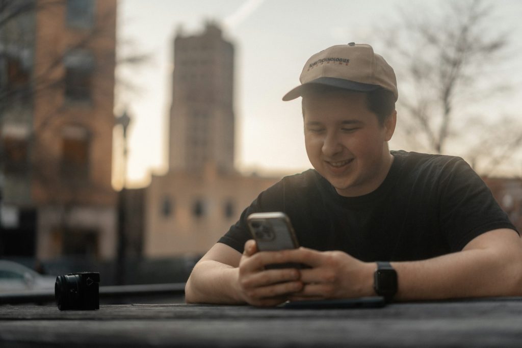 a man sitting at a table looking at his cell phone